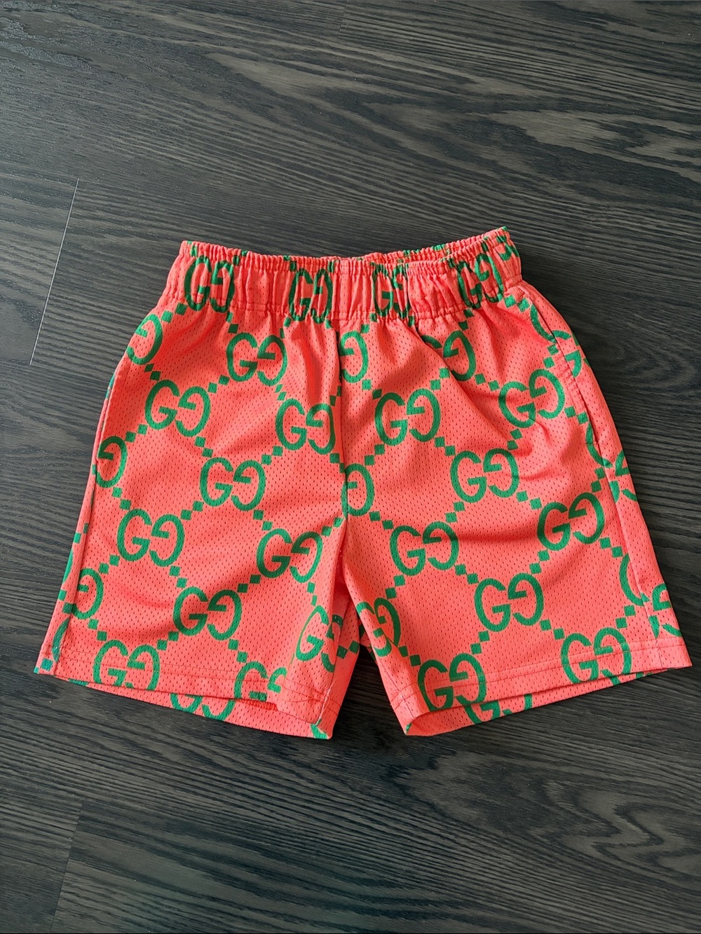 Bravest Studios Coral Pink Athletic Shorts with Green Logo Pattern
